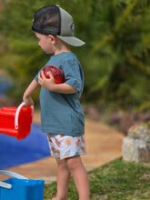 Load image into Gallery viewer, Toddler wearing a plain tee and relaxed shorts, the print on the shorts have sun, ice lollies, surf boards, coconuts and shells in muted summer colours.